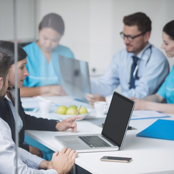 Doctors discussing laptop meeting 600x600