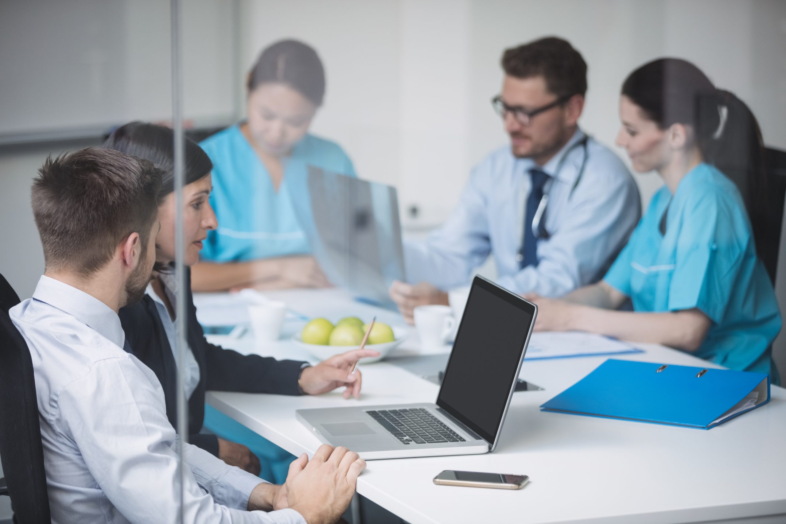 Doctors discussing laptop meeting scaled